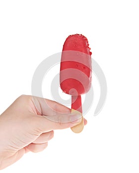 Hand holding strawberry cake popsicle isolated on white