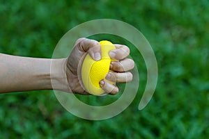 Hand holding stress ball and squeezing for relieve stress and strengthen the muscles of hand and wrist