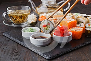 Hand holding sushi Salmon roll in chopsticks with copy space for design work