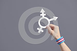 Hand holding a symbol of the transgender community with a trans flag bracelet