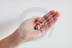 A hand is holding tablet medicines.