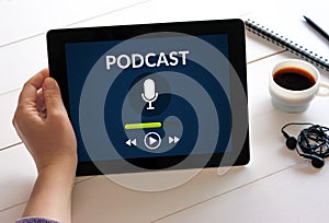 Hand holding tablet with podcast concept on screen