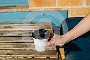 Hand holding take away coffee cup