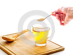 Hand holding teaspoon full of sugar