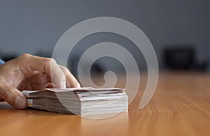 Hand holding Thai banknotes, pile of banknotes, banknotes, cash