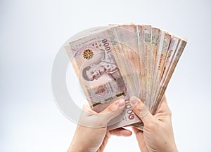 Hand holding thai money over white background, Soft focus, copy space.