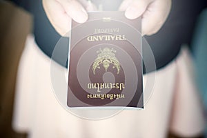 Hand holding Thailand passport