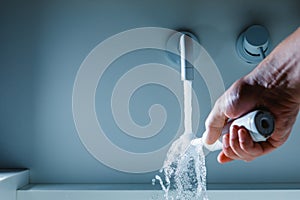 hand holding toothbrush under flowing water from faucet in a hotel