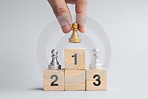 Hand holding top of golden chess pawn pieces or leader businessman. victory, leadership, business success, team, recruiting, and