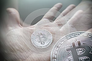 Hand holding transparent bitcoin. Tonned double exposure.