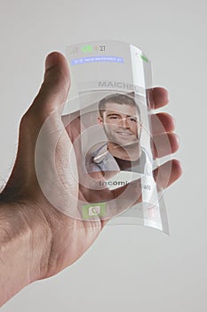 Hand holding transparent future mobile phone made of graphene. Concept.