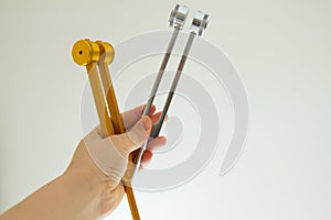 Hand holding a tuning fork and crystal stone  .