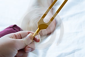 Hand holding a tuning fork and crystal stone  .