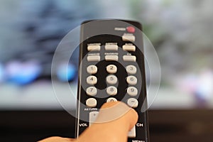 Hand Holding a TV Remote Controller