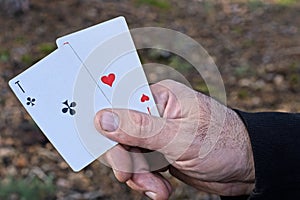 hand holding two aces from playing cards
