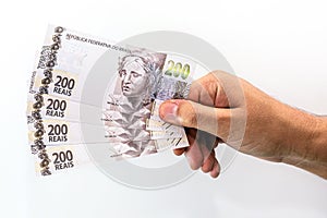 Hand holding two hundred reais bank notes, brazil money, payment concept, grand prize or profit photo