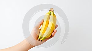 a hand holding two ripe yellow bananas against a white background photo