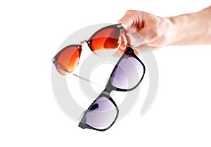Hand holding two sunglasses. Men`s and women`s sunglasses. Close