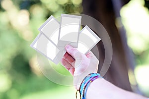 Hand holding up four blank instant photo frames