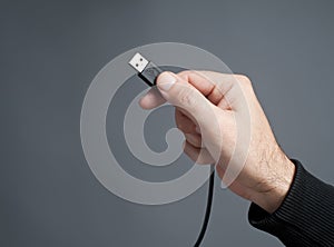 Hand holding USB cable