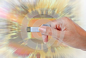 Hand holding USB data storage against light and circuit