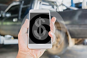 Hand holding and using mobile smart phone calculate the cost of car repair