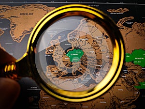 Hand holding vintage magnifying glass and focus to GERMAN map