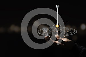 Hand holding virtual target board and arrow with bokeh background. Keeping and setup objectives and target for business investment photo