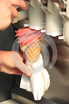 Hand holding waffle cone with twisted ice cream