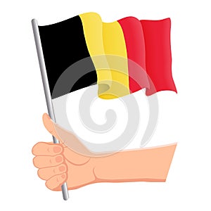 Hand holding and waving the national flag of Belgium. Fans, independence day, patriotic concept. Vector illustration