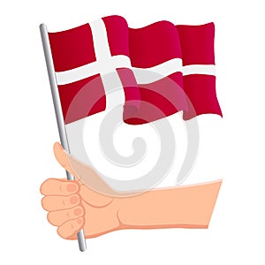 Hand holding and waving the national flag of Denmark. Fans, independence day, patriotic concept. Vector illustration