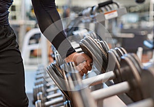 Hand holding weight dumbbell in gym close up arm muscle exercise with dumbbell.