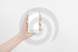 Hand holding white cellphone isolated on white clipping path inside. Online shopping. Top view. Mock up. Copy space. Template.Blan