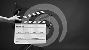 Hand is holding white Clapper board or movie slate with director chair use in video production or movie and cinema industry. It\'s