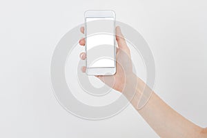 Hand holding white phone isolated on white clipping path inside. Top view.Mock up.Copy space.Template.Blank.