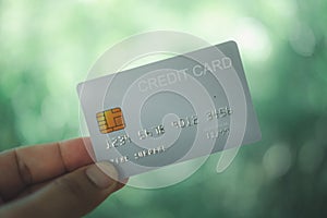 Hand holding white plastic credit card. Online shopping