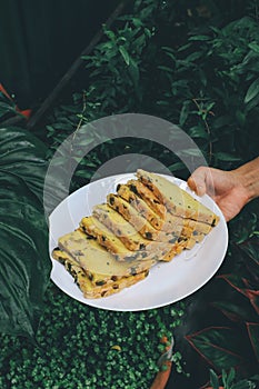 Hand holding white plate Homemade High fiber natural health food Sliced rye bread on cutting board. Whole grain rye bread with see