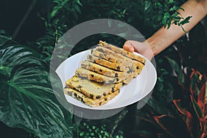 Hand holding white plate Homemade High fiber natural health food Sliced rye bread on cutting board. Whole grain rye bread with see