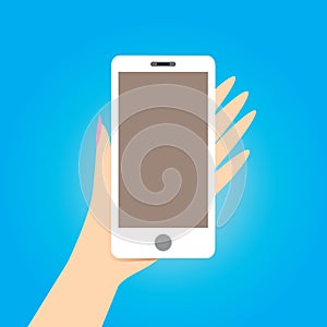 Hand holding white smart phone on blue background.