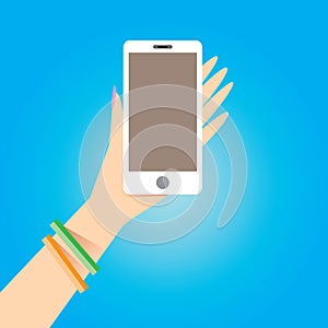 Hand holding white smart phone on blue background.