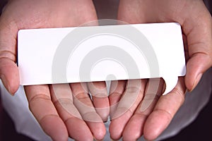 Hand holding white talk speech bubble.
