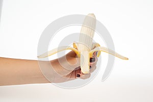 Hand holding whole banana isolated on white background