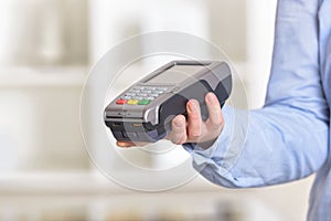 Hand holding a wireless card payment terminal