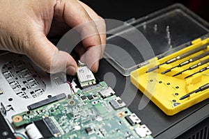 hand holding wireless chip to install on motherboard of laptop