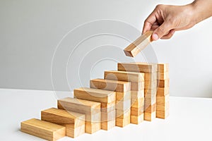 Hand holding Wood block with architecture model, Planning Alternative Risk and Strategy in Business concept