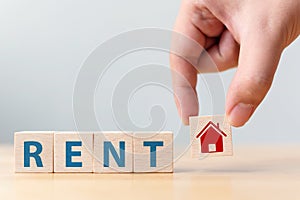 Hand holding wood cube block with icon house and word RENT. Property investment and house mortgage financial concept