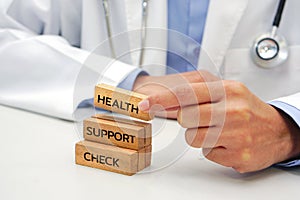 Hand holding a wooden block cube the top one with word and icon symbol. Medical and health care concept.