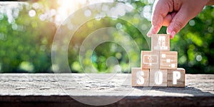 Hand holding wooden block with Standard Operating Procedure icon on virtual screen