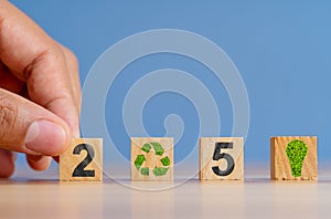 Hand holding wooden blocks with 2050 numbers mocked up as a symbol of net zero carbon emission target. photo