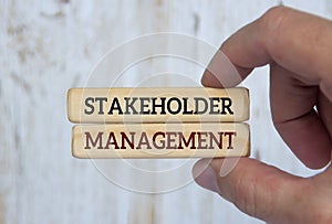 Hand holding wooden blocks with text - stakeholder management. Business relationship concept